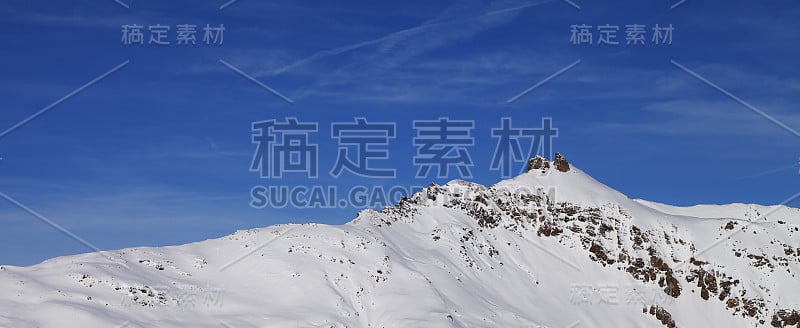 冬季高山的雪坡和阳光明媚的蓝天