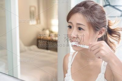 美丽的年轻女孩在她的浴室米尔刷牙