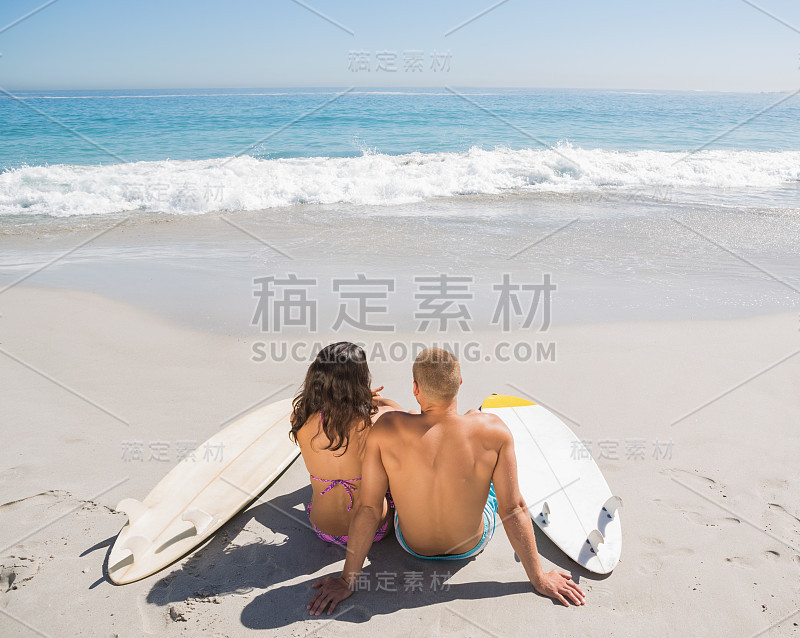 一对年轻夫妇带着冲浪板看海