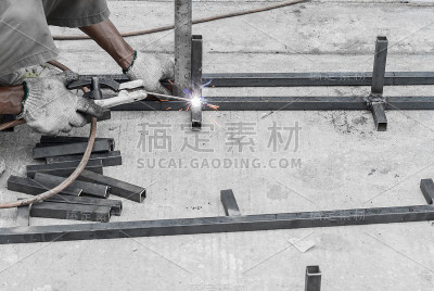 在建筑工地使用切割炬切割钢材的焊接工人