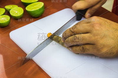 拉丁男性手在白色托盘上切水果
