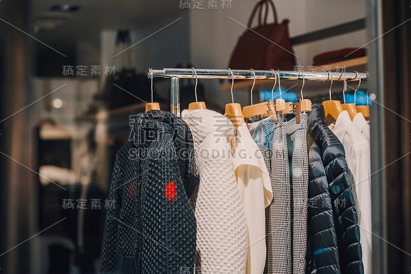 在米兰的一家商店里，妇女们穿着挂在衣架上的衣服