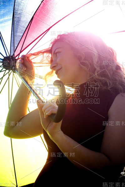 一个在阳光明媚的日子里打着伞的漂亮女人