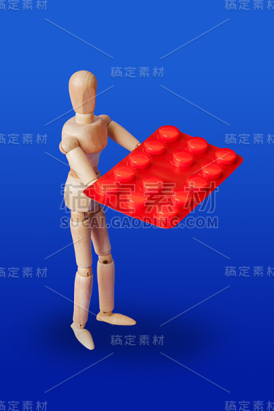 蓝色上有药丸的木制玩具人物