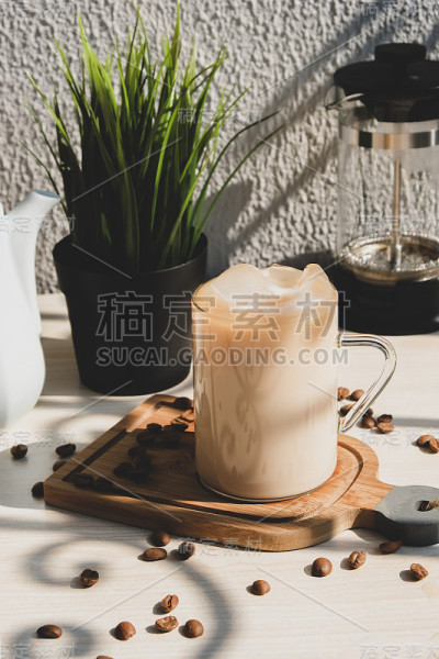 咖啡加奶油和冰牛奶，杯中有把手放在桌上。