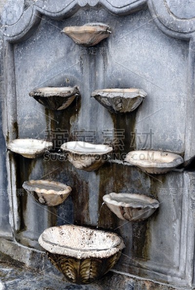 Ancient bird baths on marble wall