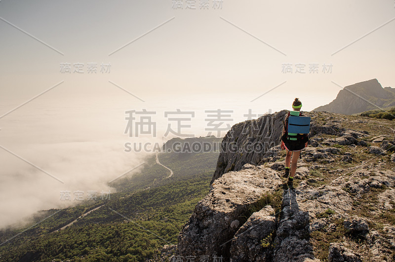 山顶上的旅行者。时尚女性徒步旅行。大气的时刻