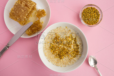 早餐:粉色背景的白色碗里有蜂花粉和蜂蜜的燕麦片