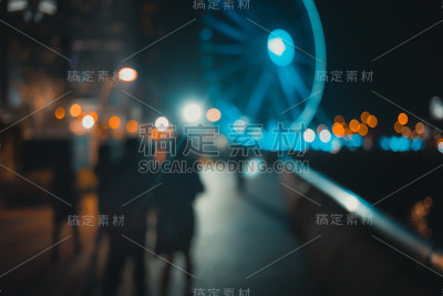 摘要散景背景下的人们在夜晚的滨水上行走
