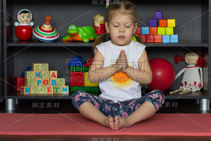 Little girl making yoga pose of cobbler or butterf