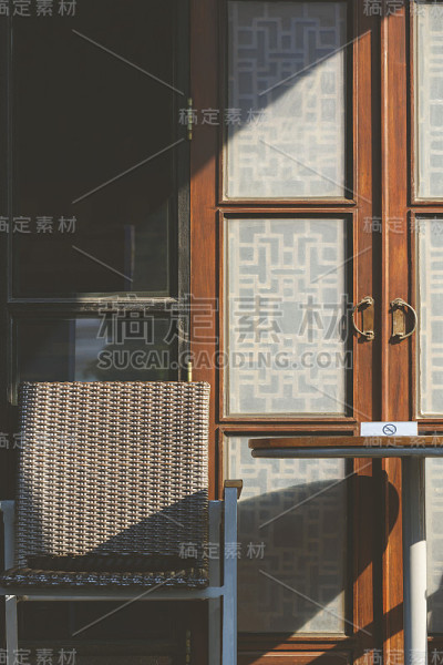 椅子和圆桌，阳光和阴影在复古的门表面，在露台区域的复古咖啡店