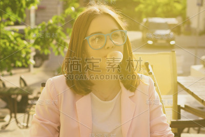 年轻漂亮的女孩在户外嚼口香糖