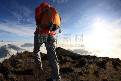 年轻女子在美丽的云峰上徒步