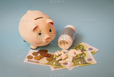小猪储蓄罐，瓶装药片和蓝色背景的欧元钞票。