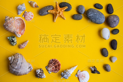 从贝壳，星星和石头的框架，夏天的概念，复制空间在黄色的背景