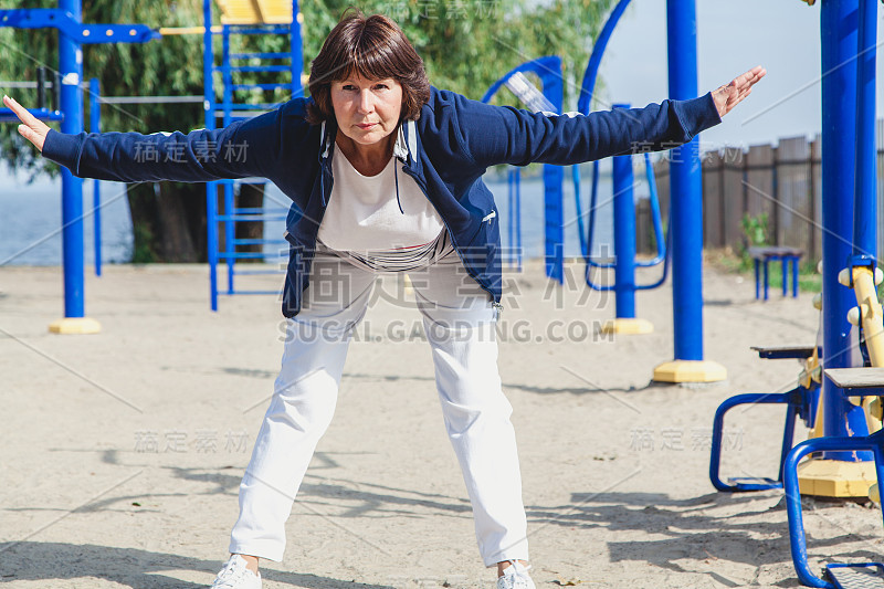 一位老年妇女在夏季运动场上做倾斜练习