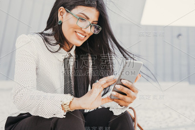 快乐的西班牙女人用智能手机上网