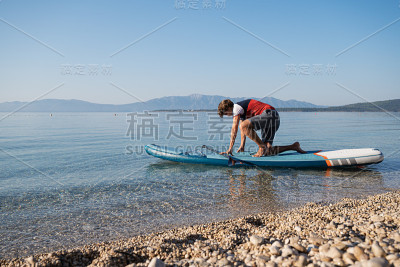 年轻人正准备在餐板上划桨