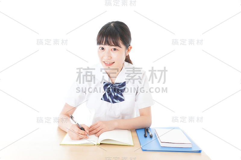 穿制服的年轻学生在书桌前学习