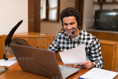 在家里工作的男人爱抚着他的猫