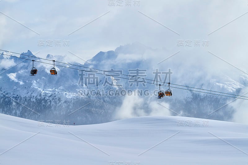 在白云岩上滑雪，出租车为滑雪者在地平线以上的背景山。Val di Fiemme，意大利。