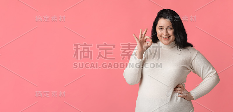 肖像的快乐超大女人微笑和显示ok手势