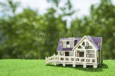 以草地和绿色植物为背景的木屋。