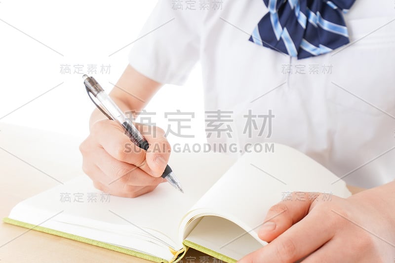 穿制服的年轻学生在书桌前学习