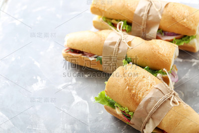 灰色的桌子上放着美味新鲜的三明治