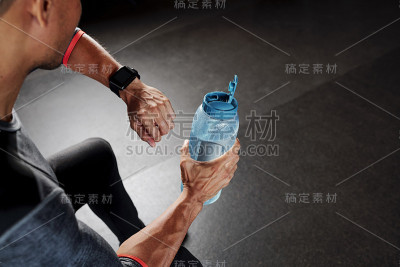 运动员喝水和检查智能手表