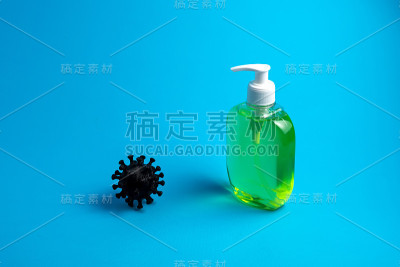 蓝色背景上的冠状病毒和液体肥皂。医院、医疗中心、实验室的概念
