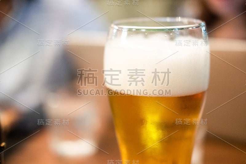 长杯新鲜淡啤酒和泡沫。近距离