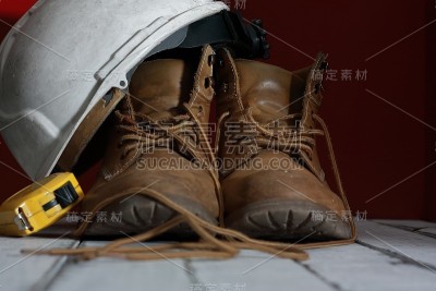 工作靴，白色建筑师头盔和米制胶带