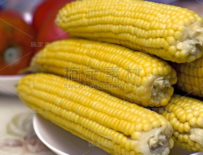 餐桌上一盘煮熟的玉米