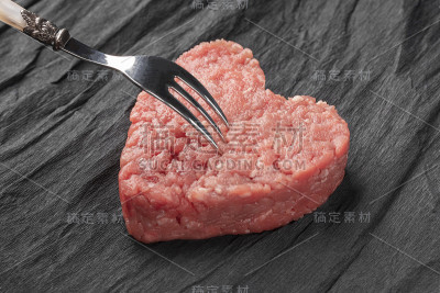 厚厚的汉堡肉饼放在黑色皱巴巴的纸上