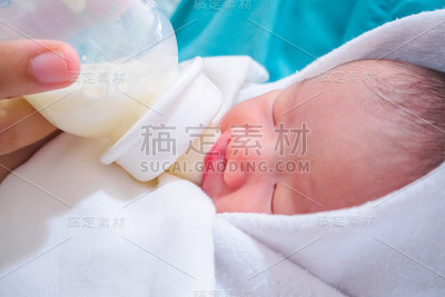 母亲用奶瓶喂新生儿
