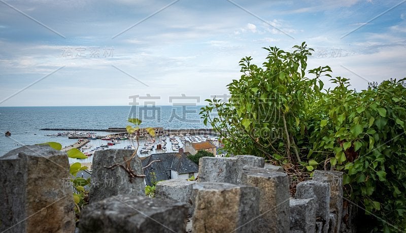 以大海为背景，石墙后的港口景色