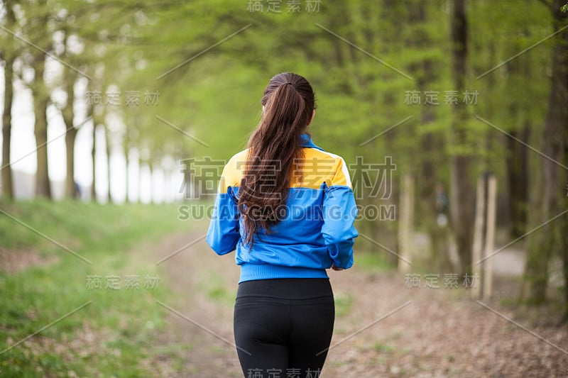 年轻漂亮的女人在小道上奔跑