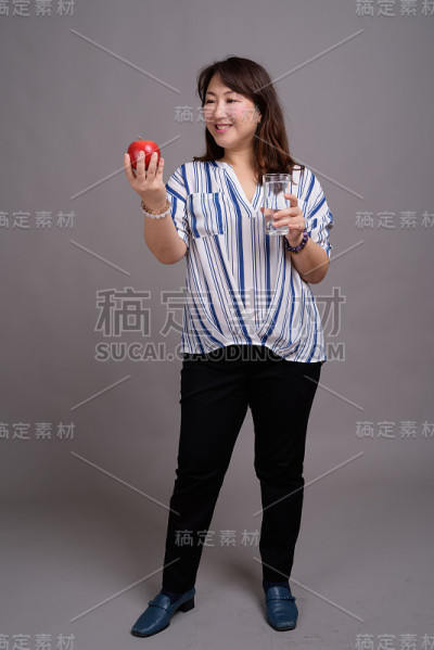 工作室拍摄的成熟美丽的亚洲女商人在灰色的背景