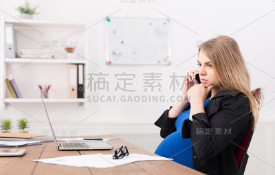 怀孕的商务女性在工作中打电话