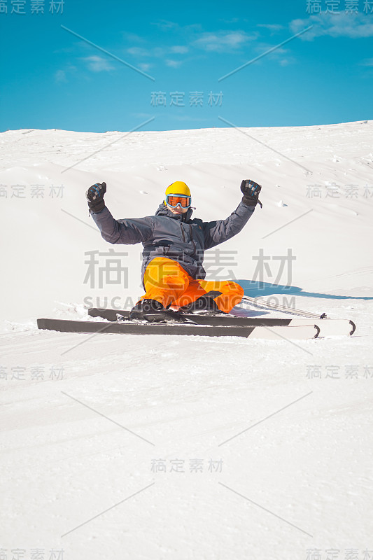 男子滑雪者坐在雪地上挥动双手兴奋不已