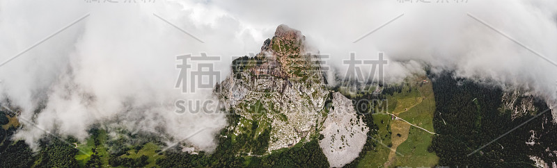 无人机全景航拍的标志性山峰被戏剧性的云包围