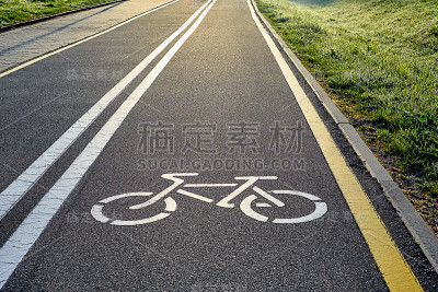 自行车白色和黄色的车道标志和图像自行车与阳光的道路