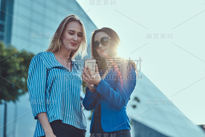 两个女人在看智能手机上的东西