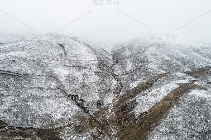 蜿蜒穿过被雪山环绕的山谷的乡村道路