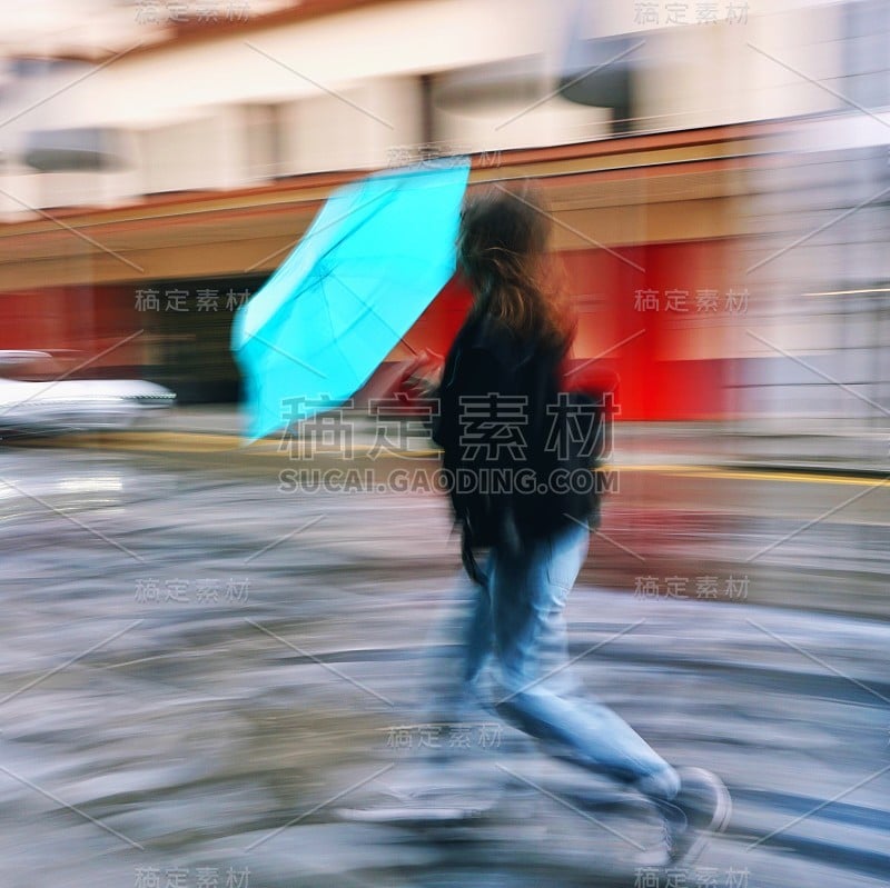 在西班牙毕尔巴鄂市，人们在雨天撑着雨伞行走