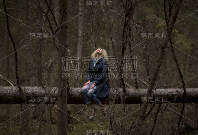 金发女孩坐在树干上