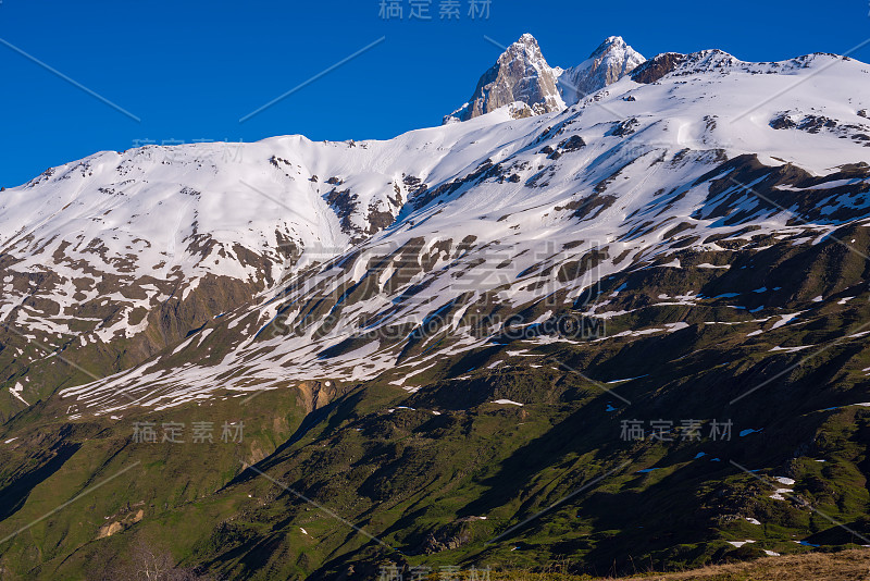 乌斯巴的岩石山峰高耸于白雪覆盖的山脉之上