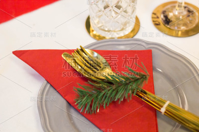 用红布和杉树枝装饰的圣诞盘子和金器