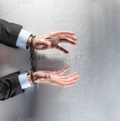 带着手铐的绝望商人在办公室里乞讨和抱怨